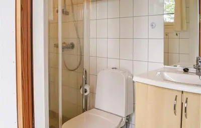 a bathroom with a toilet and a sink and a shower at Stunning Home In Sjusjøen With Kitchen in Sjusjøen