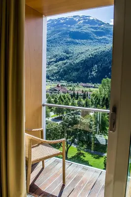 a balcony with a chair and a view of a mountain at Hotel Alexandra Loen in Loen