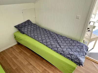 a bed in a small room with a green mattress at 6 person holiday home in ETNE in Etnesjøen