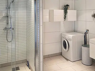 a bathroom with a washing machine and a shower at 6 person holiday home in Urangsvåg in Steinsbø