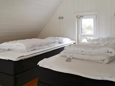 two beds sitting in a room with a window at 6 person holiday home in Urangsvåg in Steinsbø