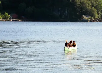 three people in a boat on a lake at Tysnes Sjø og Fritid in Uggdalseidet