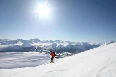 a person is skiing down a snow covered mountain at Romsdalseggen Lodge in Isfjorden