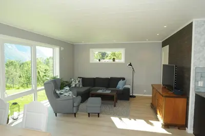 a living room with a couch and a tv at Romsdalseggen Lodge in Isfjorden