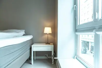 a bedroom with a bed and a table with a lamp at Forenom Serviced Apartments Bergen City in Bergen