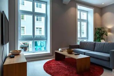 a living room with a couch and two windows at Forenom Serviced Apartments Bergen City in Bergen