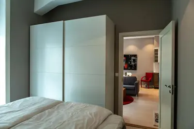 a bedroom with a large white closet and a bed at Forenom Serviced Apartments Bergen City in Bergen