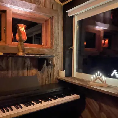 a piano sitting next to a window in a room at Eikre Fjellgård in Hemsedal