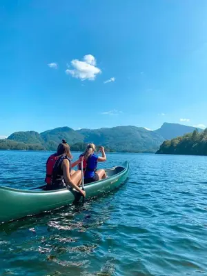 two people sitting in a kayak on a lake at Eidegrend Boutique Hotel in Eikelandsosen