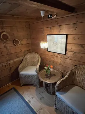 a living room with two chairs and a table at Eidegrend Boutique Hotel in Eikelandsosen
