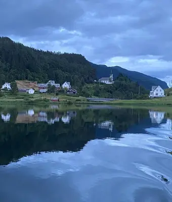 a large body of water with houses and trees at Eidegrend Boutique Hotel in Eikelandsosen