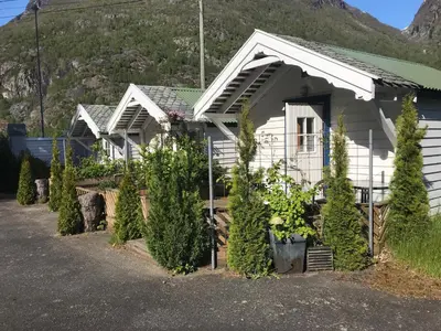 a white house with plants in front of it at Eidfjord Hytter in Eidfjord