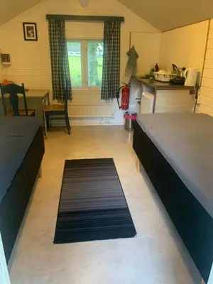 a room with two beds and a rug on the floor at Eidfjord Hytter in Eidfjord