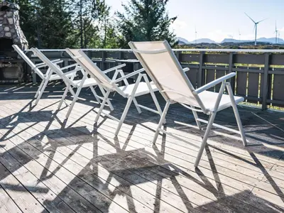 three white chairs sitting on top of a deck at Holiday Home Sjøbuvågen by Interhome in Korssund