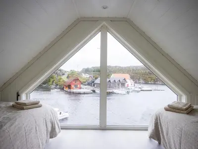 two beds in a room with a large window at Holiday Home Brosme by Interhome in Bømlo