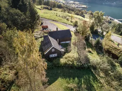 an aerial view of a house on a hill next to the water at Chalet Eiketun by Interhome in Olden