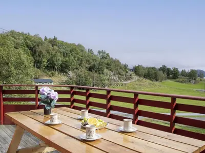 a wooden table with drinks and flowers on a balcony at Holiday Home Fjordglytt by Interhome in Onarheim