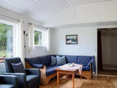 a living room with a blue couch and a table at Holiday Home Fjordglytt by Interhome in Onarheim