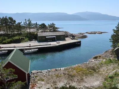 a house on a dock in a body of water at Holiday Home Nesholmen by Interhome in Leirvik