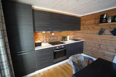 a kitchen with wooden walls and black cabinets at Lake View Apartment 2 bedrooms and loft in Stranda