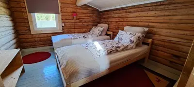 a bedroom with two beds in a log cabin at Ønskedrømmen hytteutleie in Brandbu