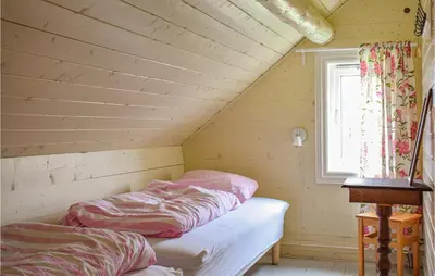 two beds in a attic room with a window at Solvang in Hebnes