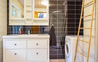 a bathroom with a sink and a washing machine at Solvang in Hebnes