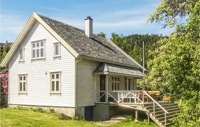 an old white house with a porch and a staircase at Solvang in Hebnes