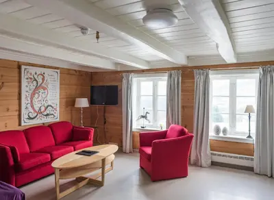 a living room with a red couch and two chairs at Store Ringheim Hotel og Restaurant in Vossevangen