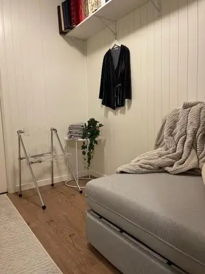a bedroom with a bed and a black jacket hanging on a wall at Moderne hytte in Gjøvik