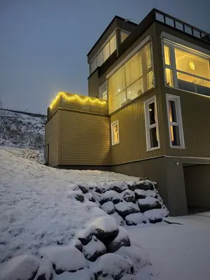 a house in the snow with lights on it at Moderne hytte in Gjøvik