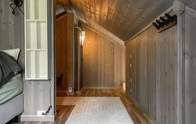 a bedroom with wooden walls and a wooden floor at Lovely Home In Rendalen With Wifi in Rendalen