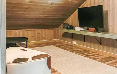 a room with a bed and a tv and a table at Lovely Home In Rendalen With Wifi in Rendalen