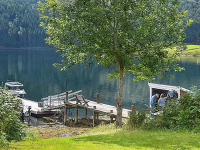 a group of people sitting on a dock on a lake at Seaside Serenity in Settem Fjord-By Traum in Bø