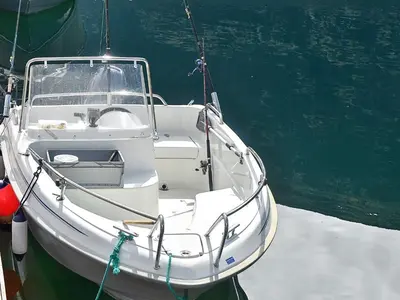 a white boat is docked in the water at Seaside Serenity in Settem Fjord-By Traum in Bø