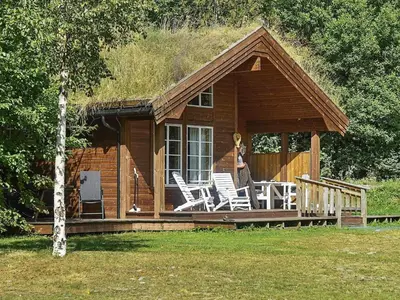 a log cabin with chairs and a grass roof at Seaside Serenity in Settem Fjord-By Traum in Bø