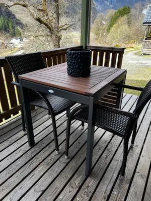 a wooden table and two chairs on a deck at Gjørven Hytter in Flåm