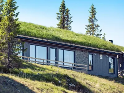 a house with a grass roof on top of a hill at 10 person holiday home in Fåvang in Favang