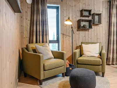 a living room with two chairs and a lamp at 10 person holiday home in Fåvang in Favang