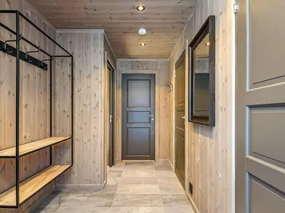 a hallway with wooden walls and a blue door at 10 person holiday home in Fåvang in Favang