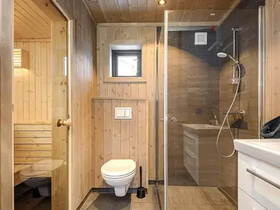 a wooden bathroom with a toilet and a shower at 10 person holiday home in Fåvang in Favang