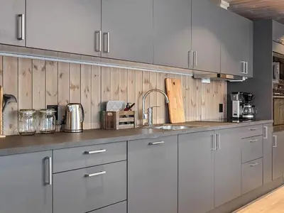 a kitchen with gray cabinets and stainless steel appliances at 10 person holiday home in Fåvang in Favang