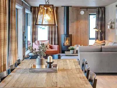 a dining room with a table and a living room at 10 person holiday home in Fåvang in Favang