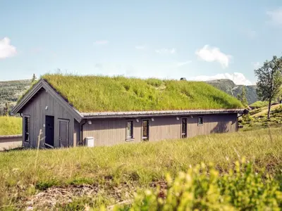 a house with a grass roof on top of it at 10 person holiday home in Fåvang in Favang