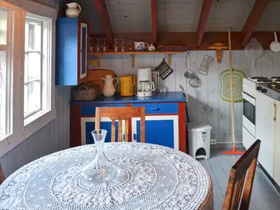 a kitchen with a table with a wine glass on it at Vintage Charm by the Sea-By Traum in Bø