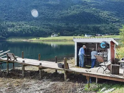 a man and woman standing in a shed on a dock at Vintage Charm by the Sea-By Traum in Bø