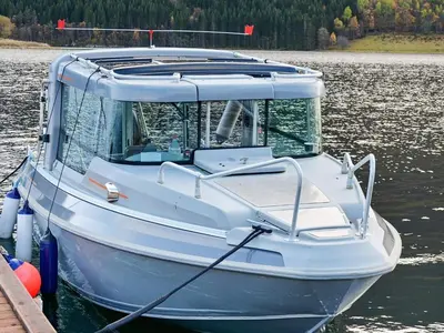 a white boat docked at a dock in the water at Vintage Charm by the Sea-By Traum in Bø