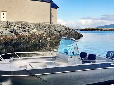 a boat sitting in the water next to a building at 10 person holiday home in Brattvåg in Brattvåg