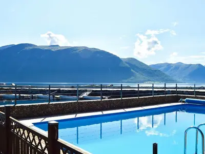 a swimming pool with a view of the water and mountains at 5 person holiday home in EIDSVÅG in Eidsvåg