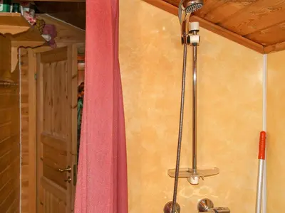 a shower with a pink curtain next to a door at 4 person holiday home in Leirvik i Sogn in Leirvik